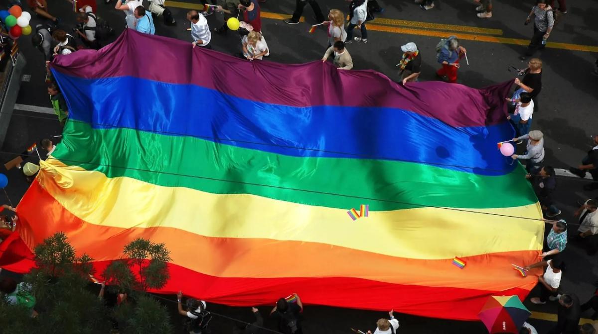 Pride Flag shown from above at a parade.