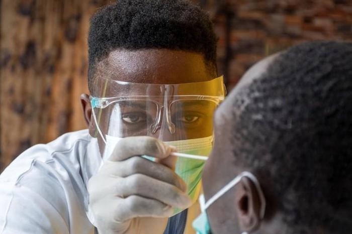 Medical personnel in Nigeria take a nasal swab for COVID testing.