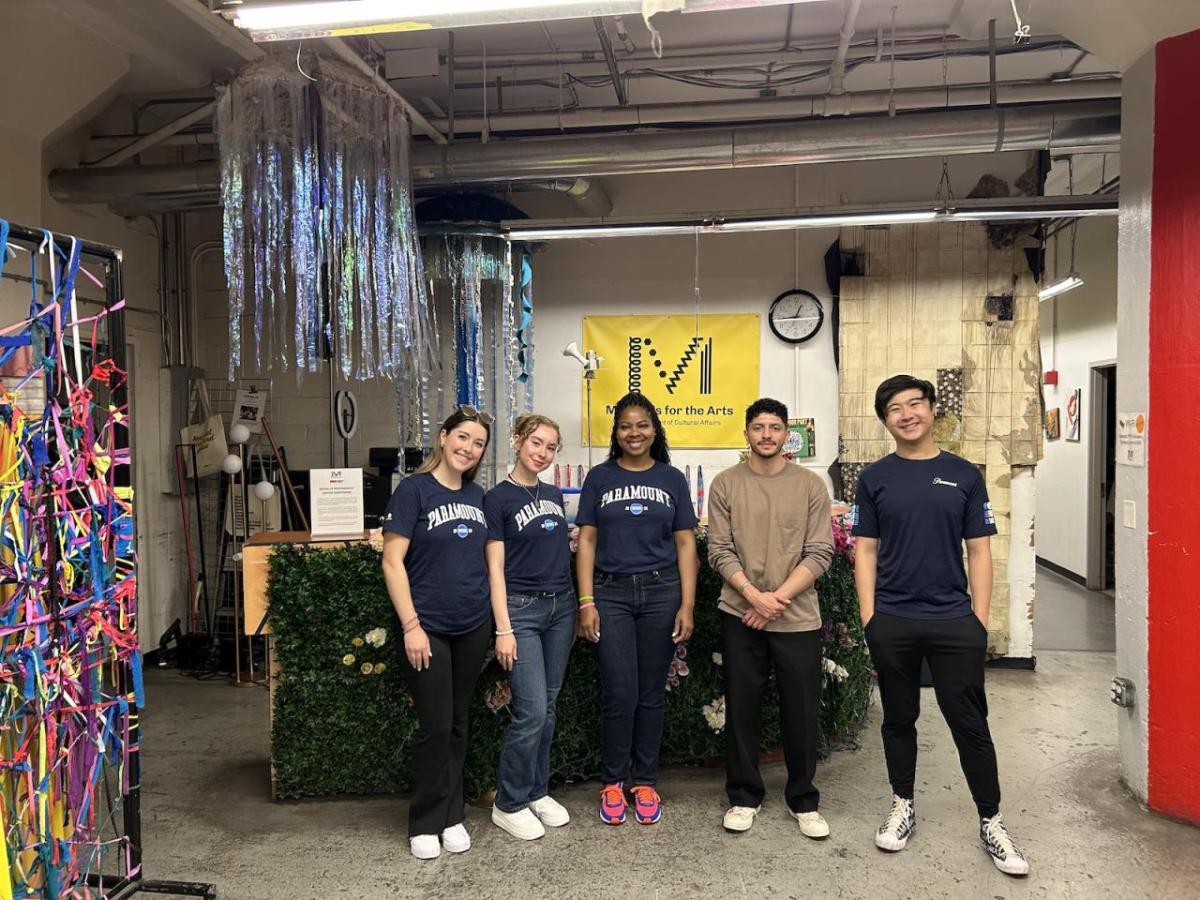 five volunteers in a decorated, industrial environment