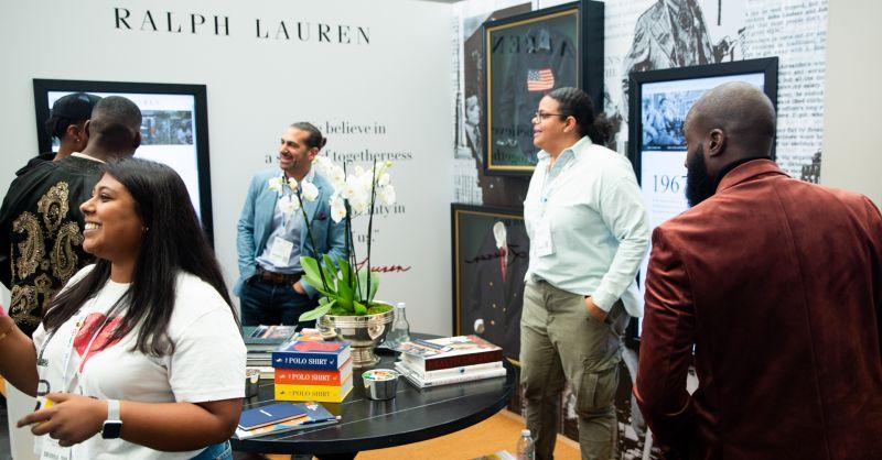 a room of people looking at displays on the walls