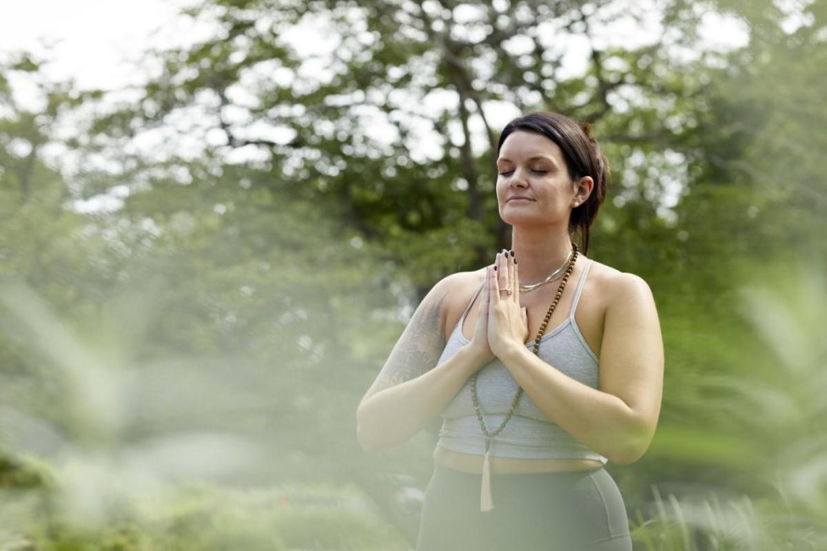 Kimberly Hoffmann doing a yoga pose outside.