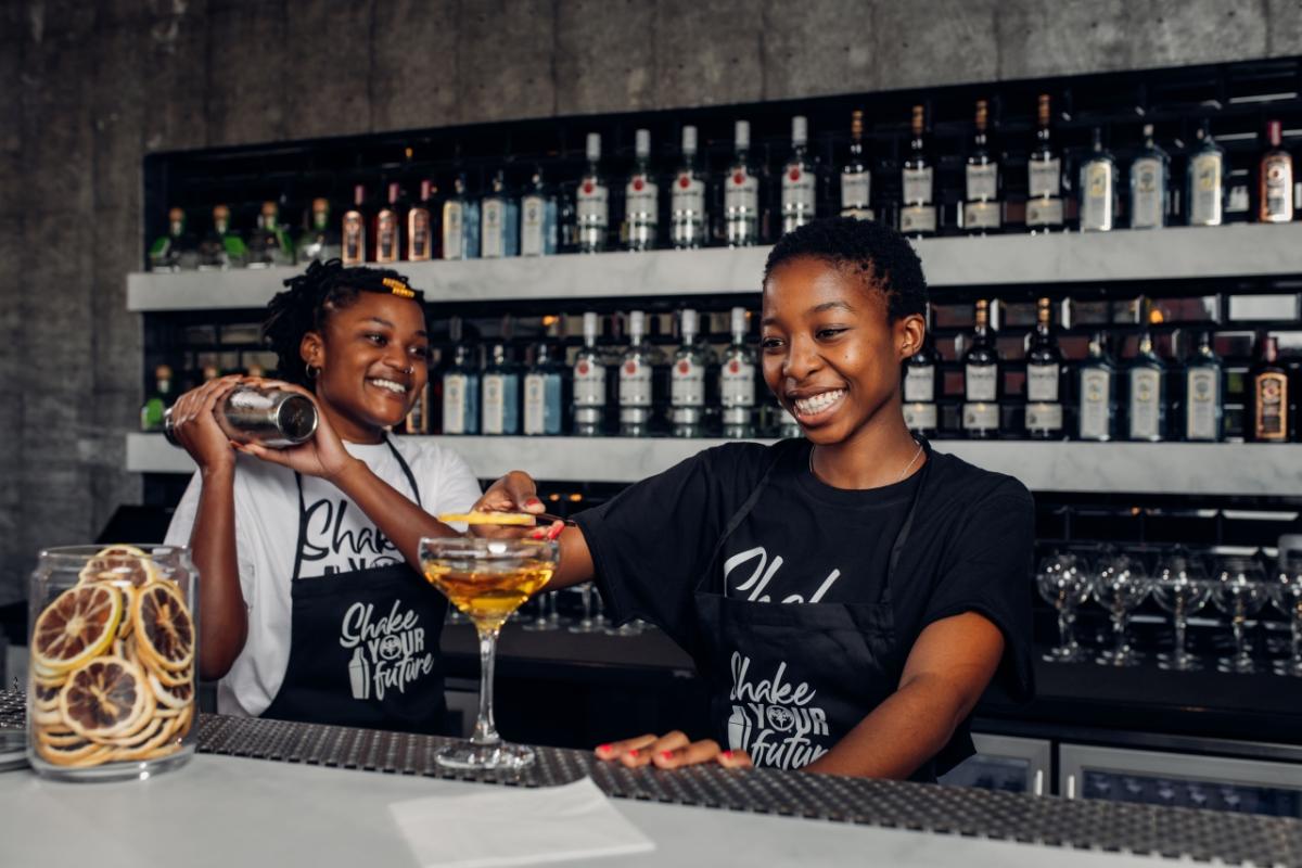 two women mixing drinks