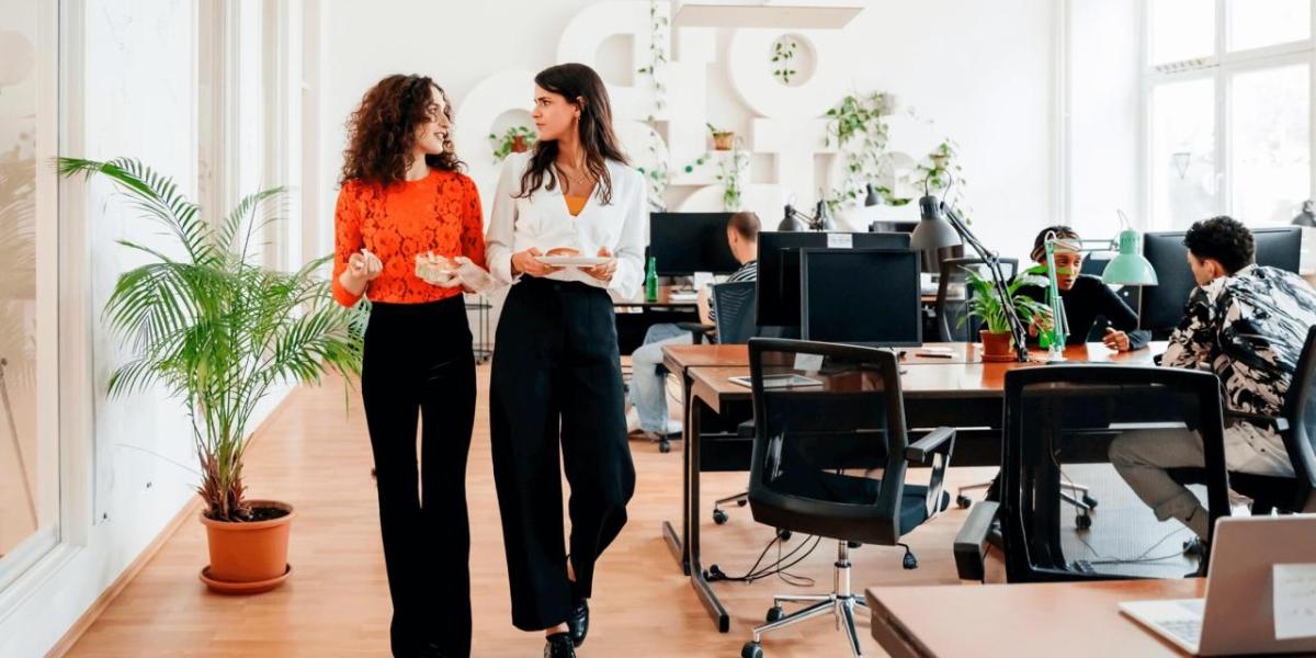 Two people walking together through an office room 