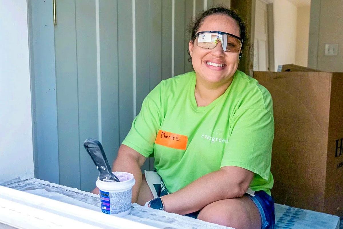 A smiling volunteer sitting in an open window.