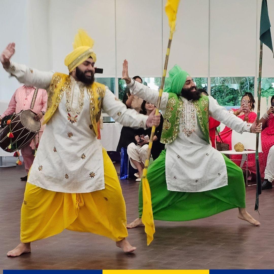 Two people dancing in AAPI cultural garments