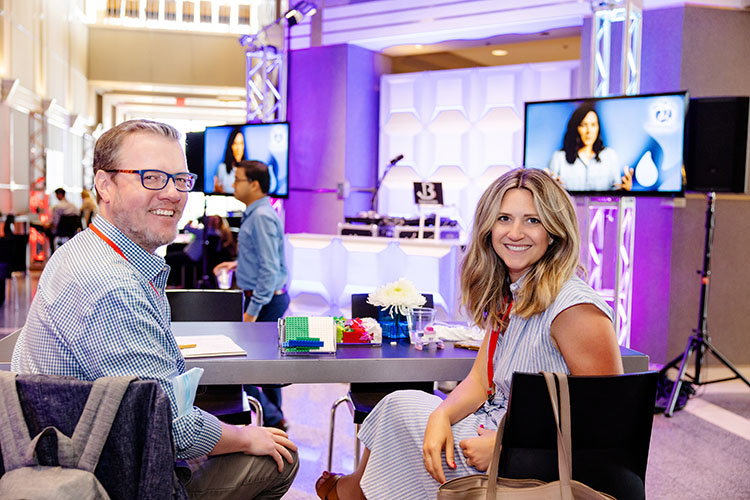 2 people smiling at conference booth