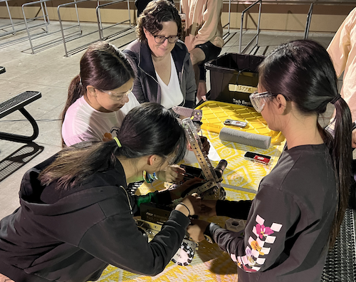 A group of youth and adults working on a robot.