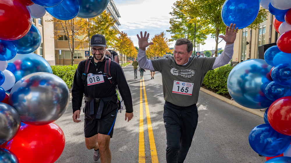 Two participants at the finish line, one with raised hands.