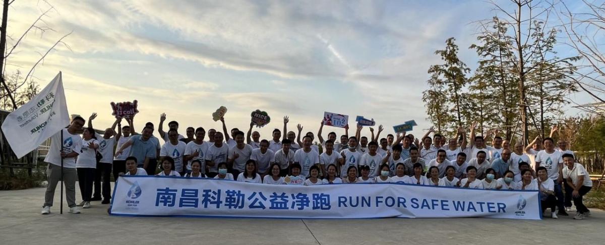 A large group outside behind a banner "Run for safe water."