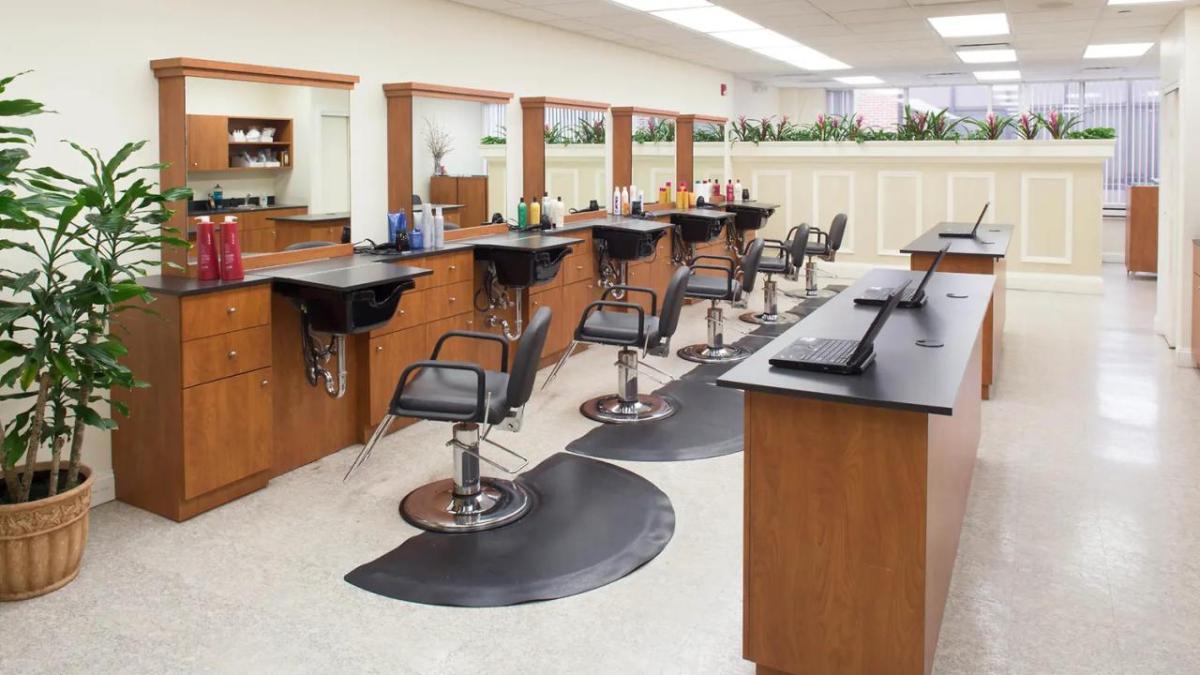 Hair salon with five chairs aligned in front of stations.