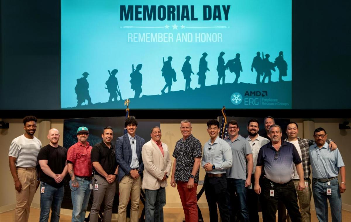 Veterans posing on a stage underneath a large screen that says "Memorial Day - Remember and Honor"