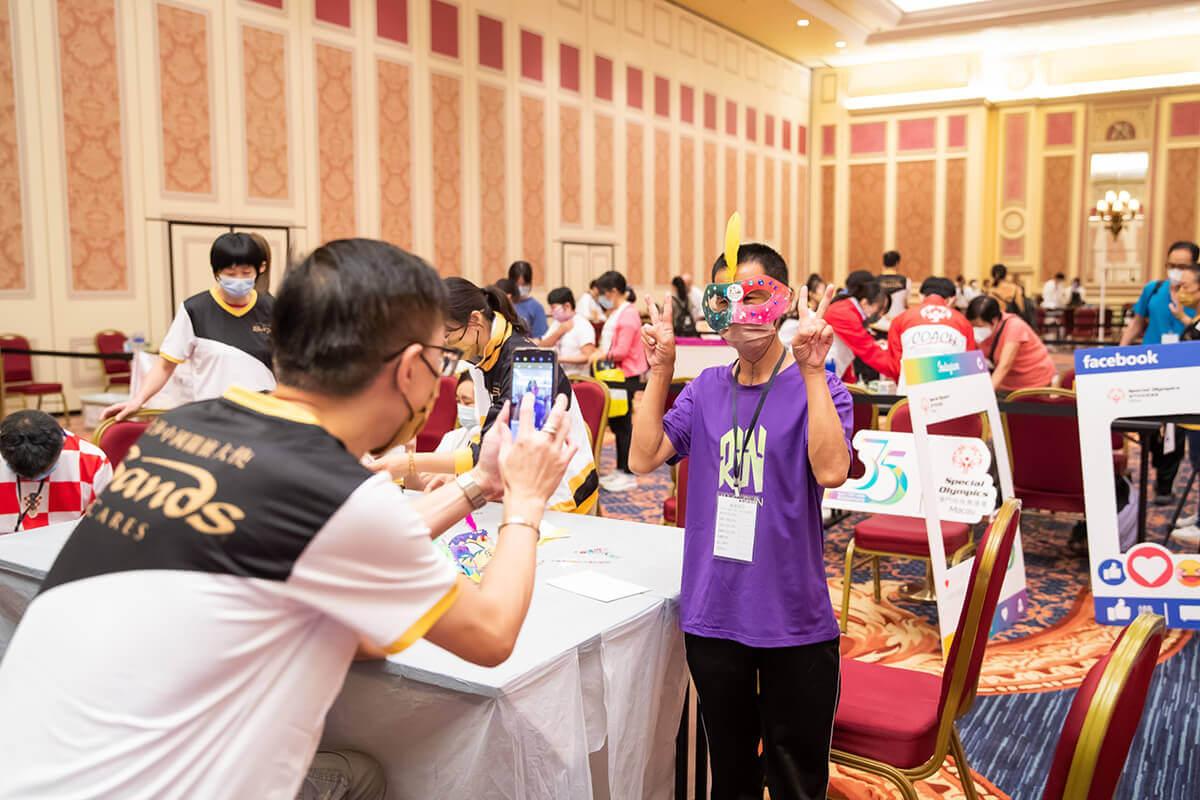 One individual taking a photo of another holding up two peace signs