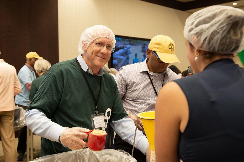 Volunteers talking as they scoop food.