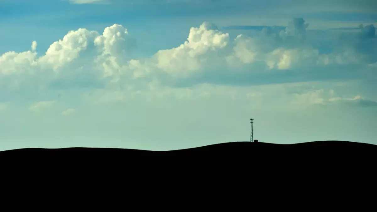 Silhouette of land with a blue cloudy sky 