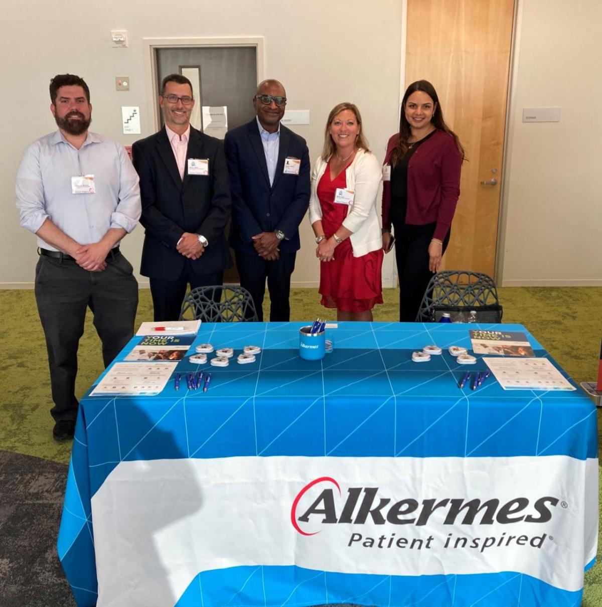 Members of Alkermes’ MOSAIC employee resource group standing behind a table 