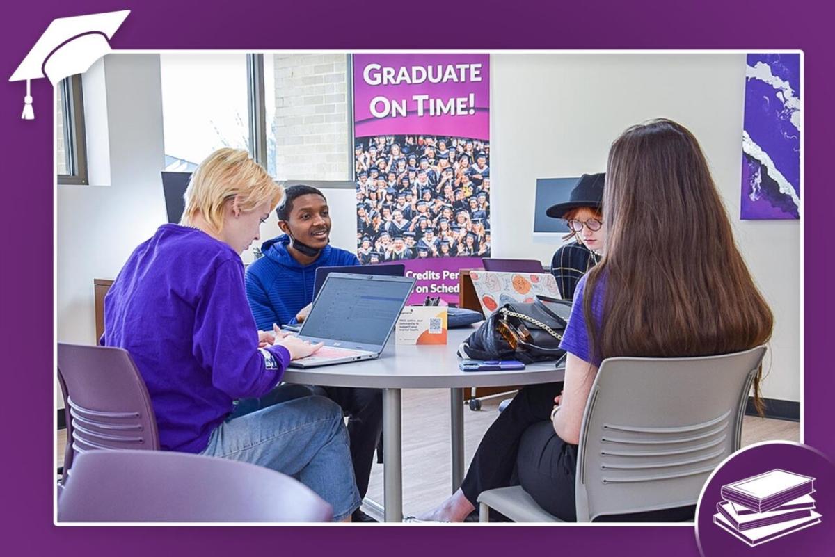 Students with open laptops seated at a circular table.