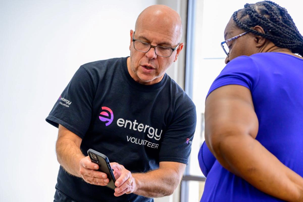 A volunteer and another person looking at a cell phone.