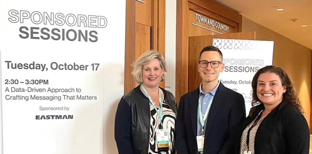 Three people stood in front of "Sponsored sessions" event banner