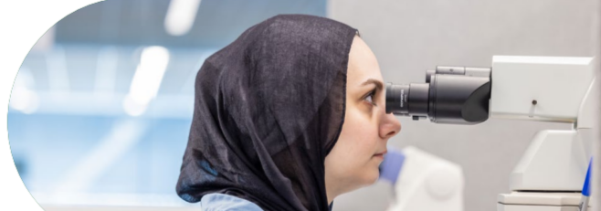 A person looking in a microscope.