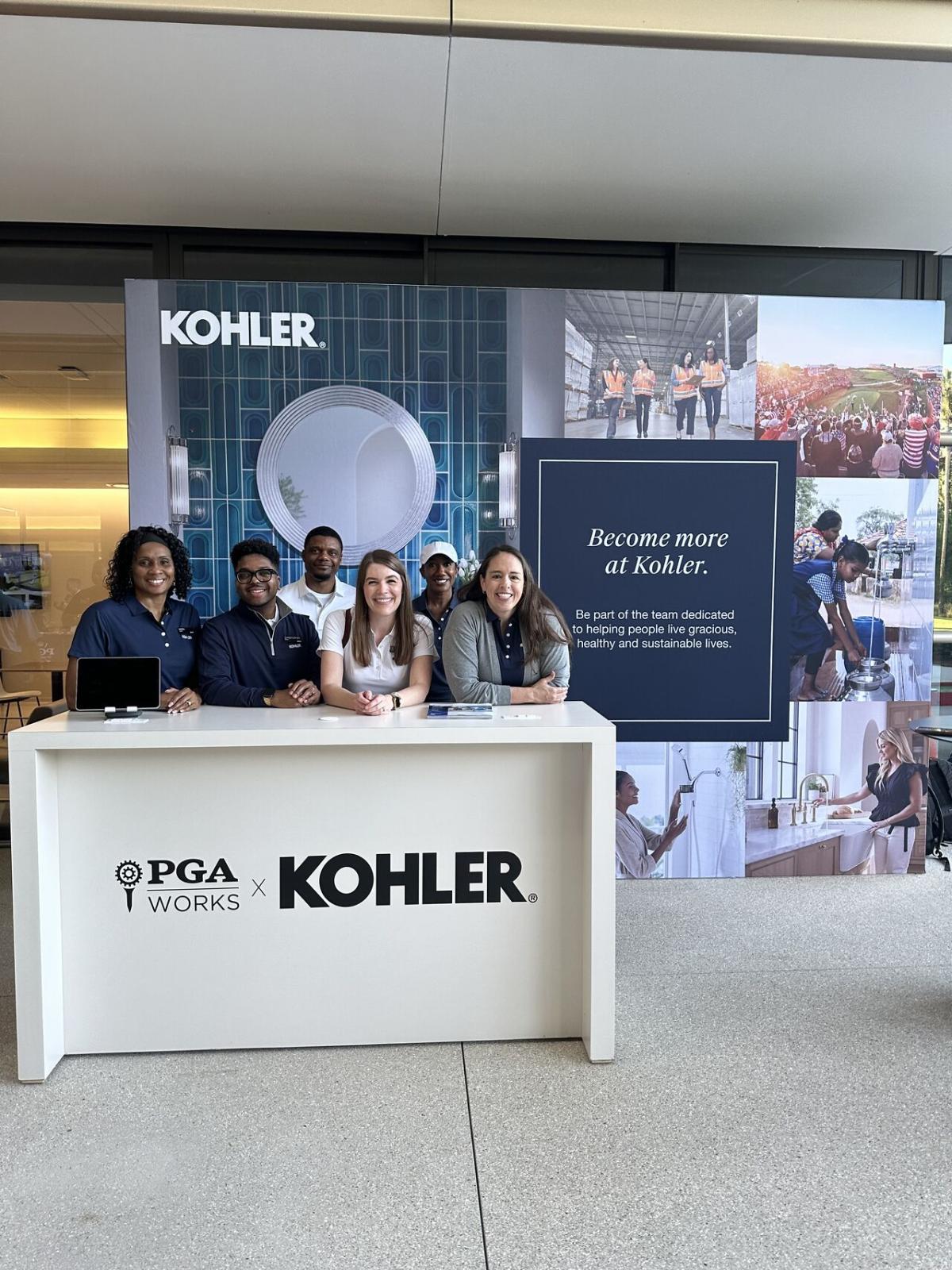 A group posed behind a podium "PGA Works x Kohler" a large display behind them.