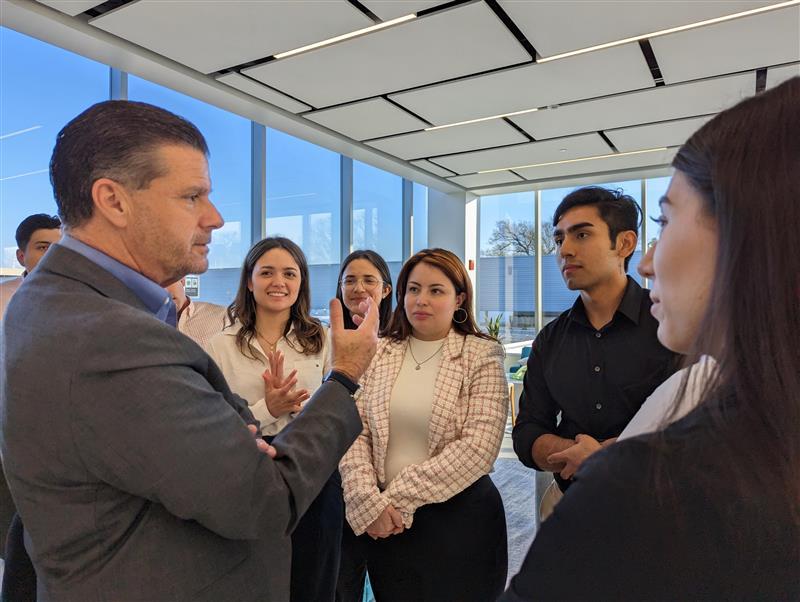 Person speaking to a small group in an office setting.