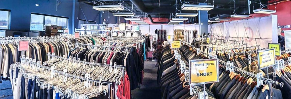 Many racks of clothing in a room.