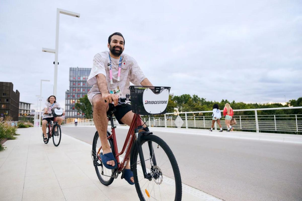 Smiling people riding bicycles on a road.