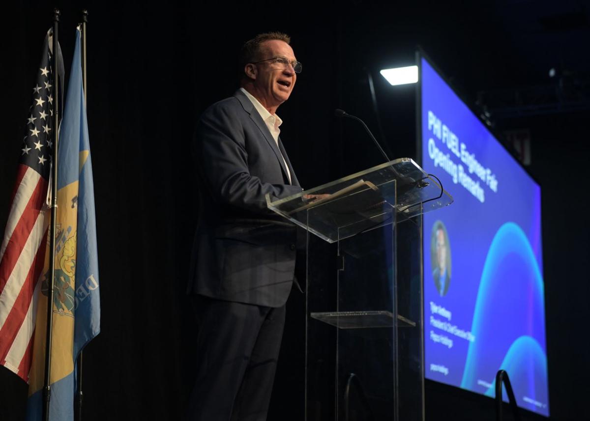 A person speaking at a podium on a stage.