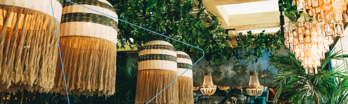 Decorative lighting and chandeliers with greenery at a venue.