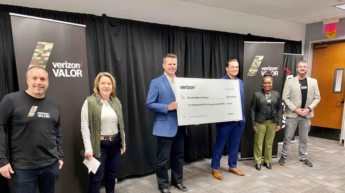 People holding up large donation check