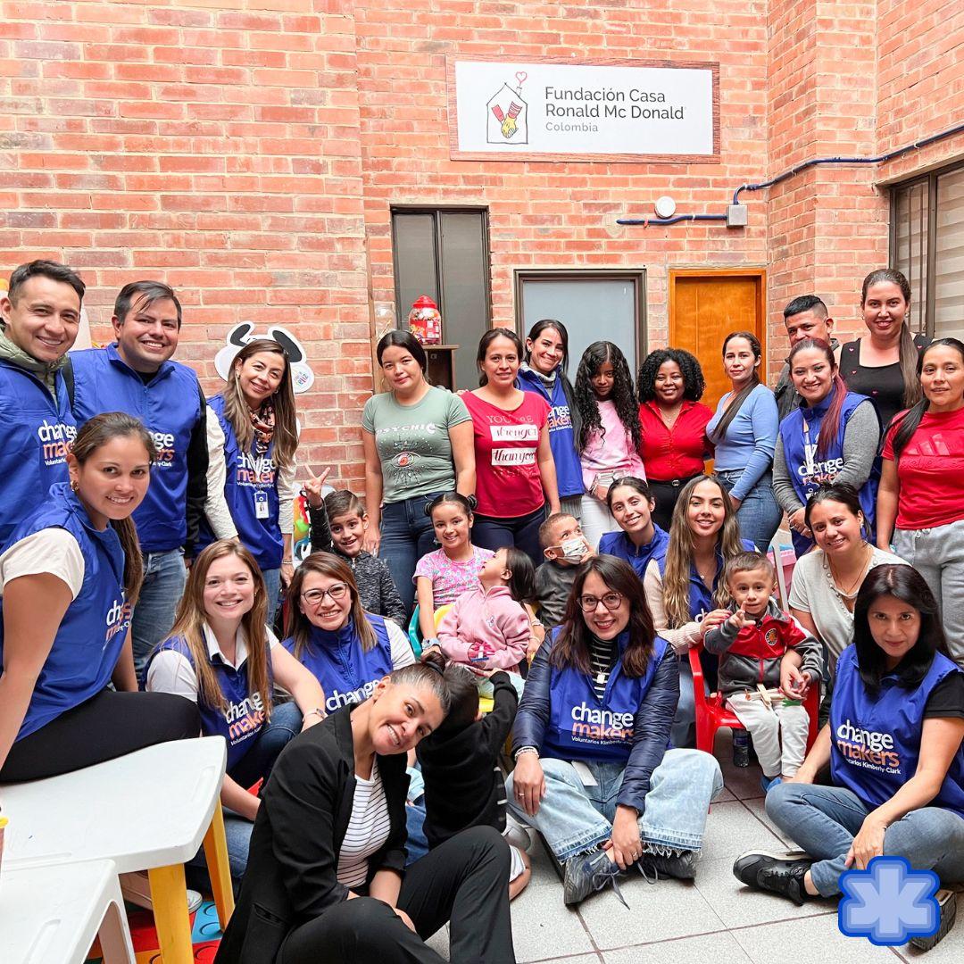 A group of volunteers and families in a courtyard.
