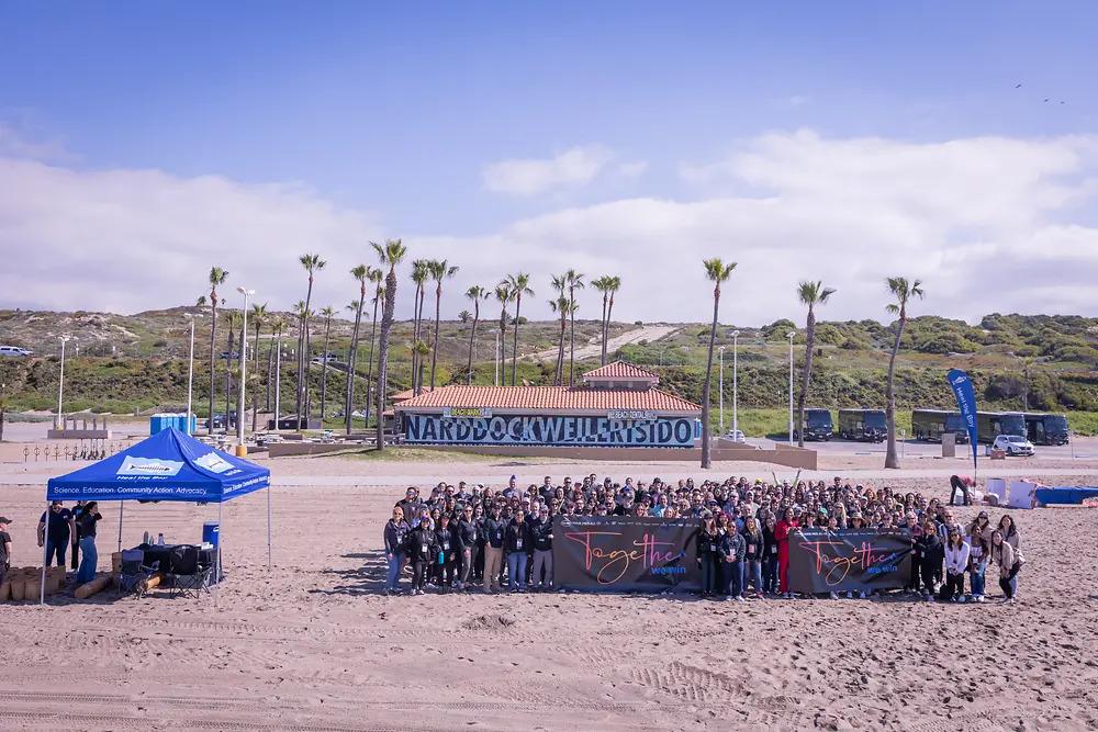 A group of people posed on a large beach.